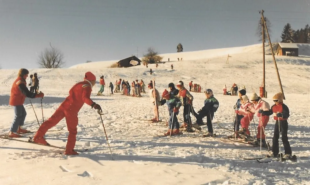 Ein Skilehrer bringt Kindern das Skifahren bei.